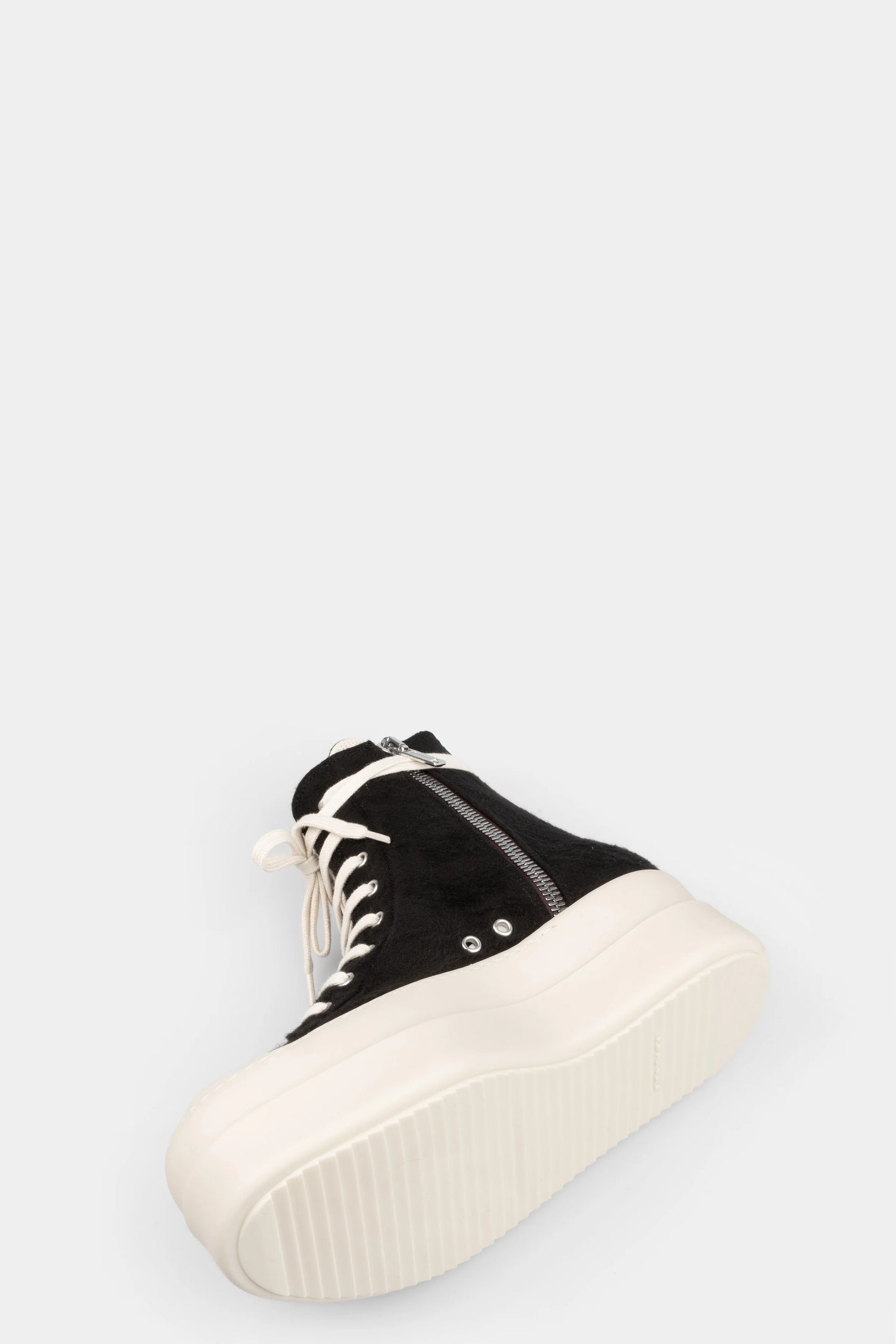 Black high-top sneaker with white sole on a light gray background