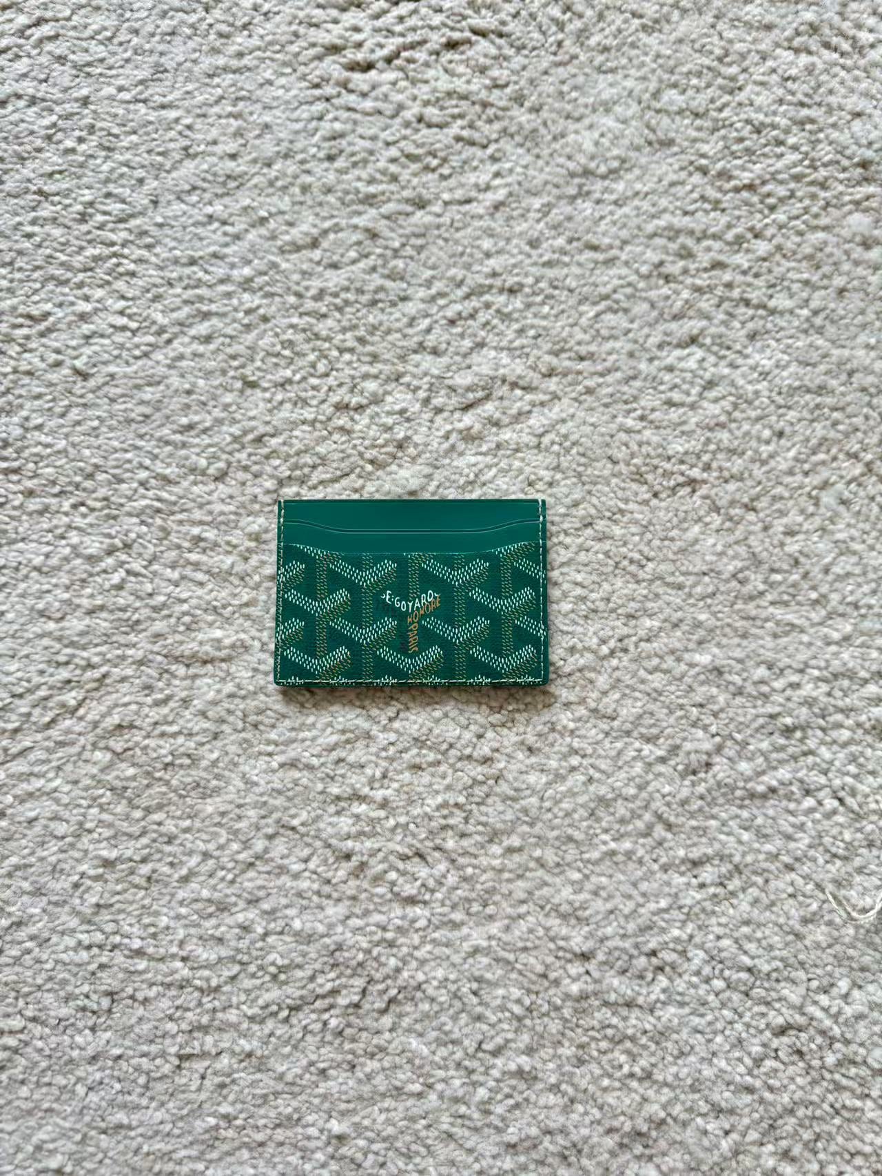 Green cardholder with pattern on a textured gray surface