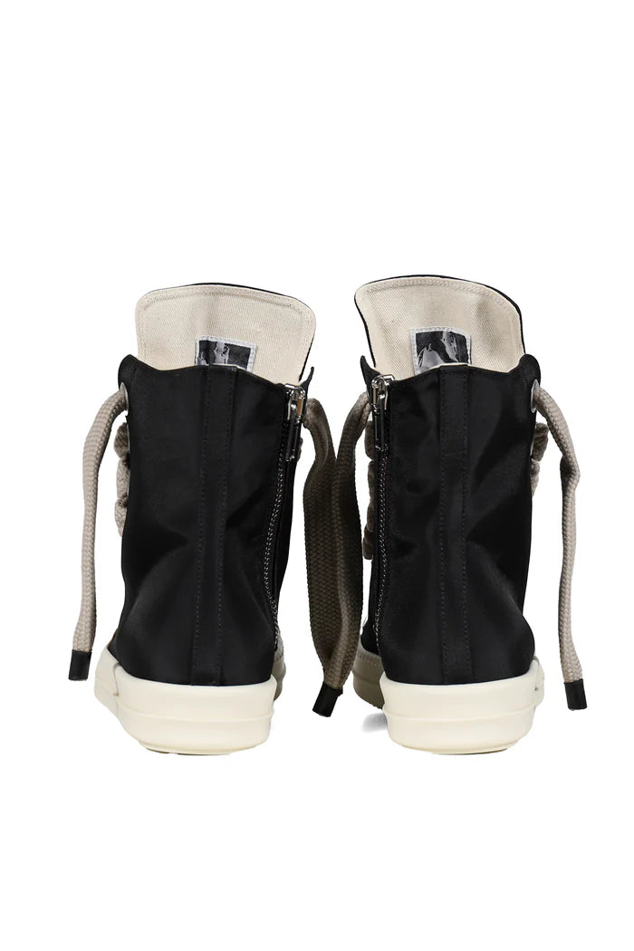 Black high-top sneakers with white soles on a white background