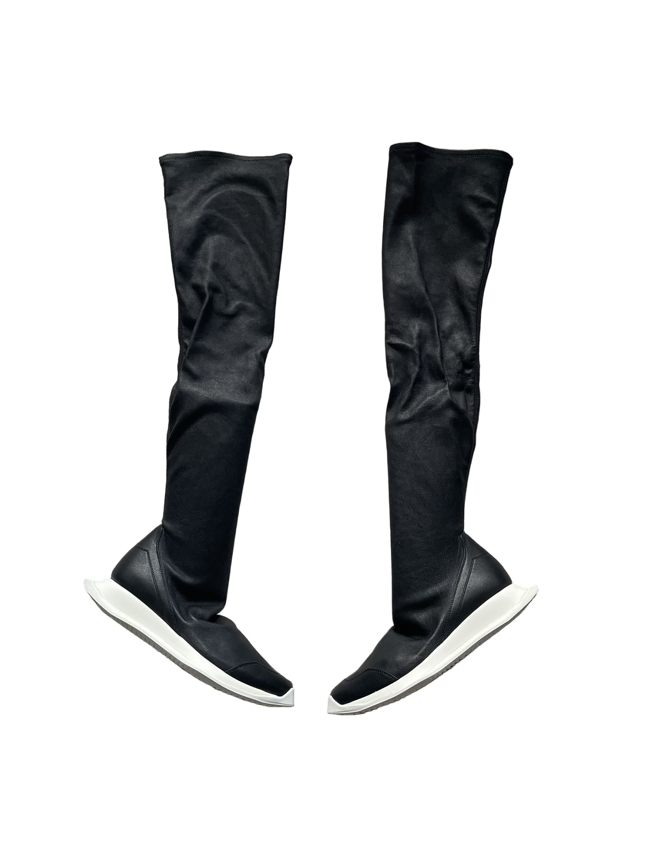 Black knee-high boots on a gray textured surface