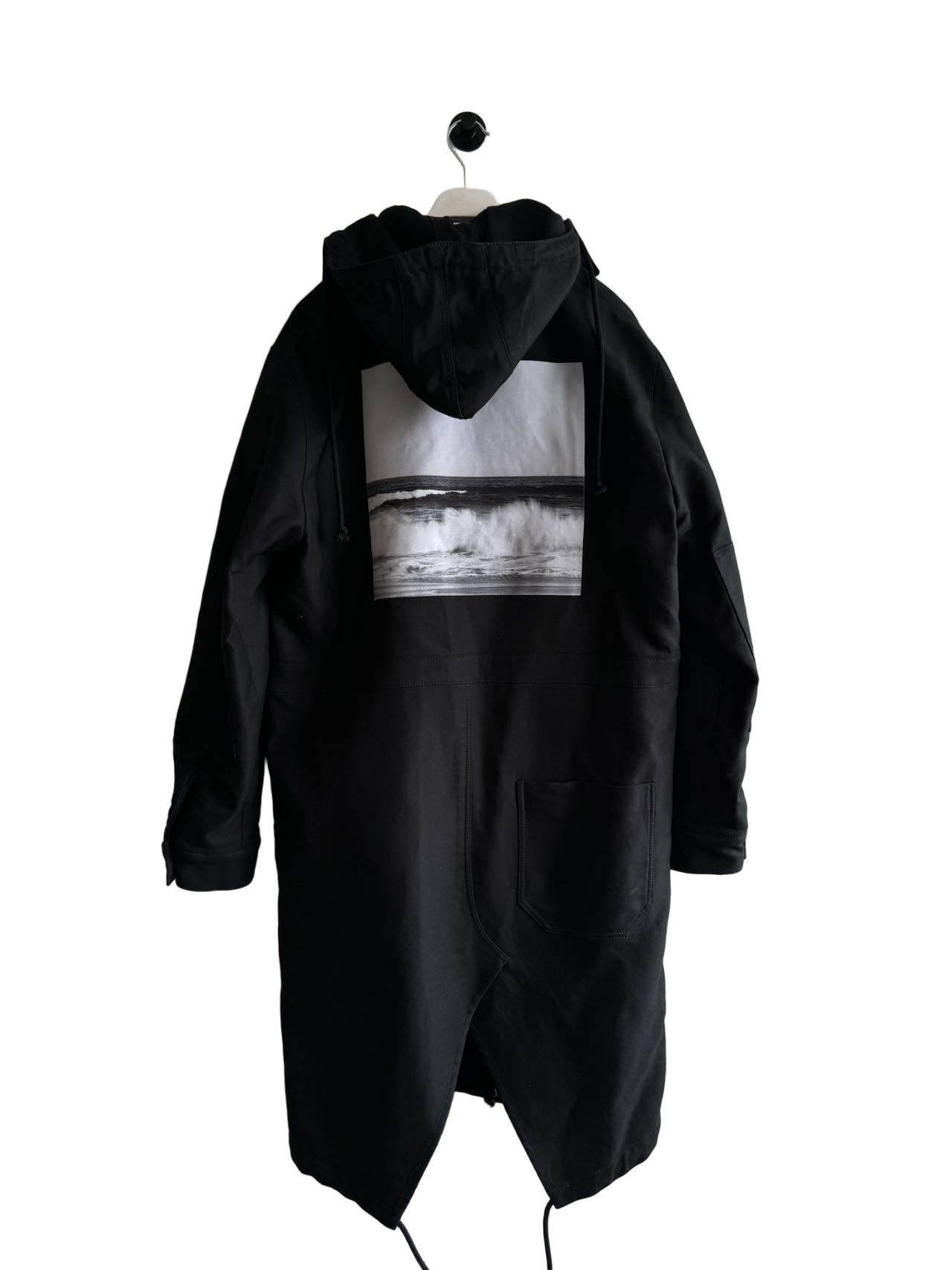 Black hooded coat with a graphic design on a white wall