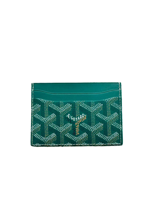 Green cardholder with pattern on a beige carpet