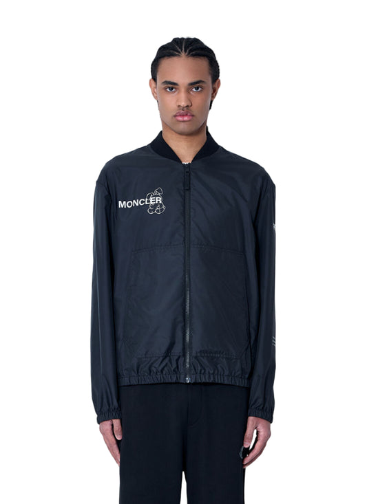 Person wearing a black Moncler jacket against a white background