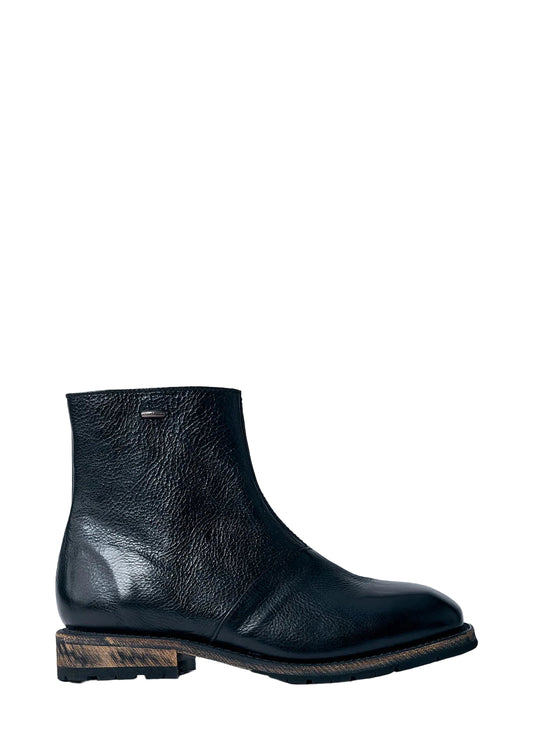 Black leather ankle boot on a light blue background